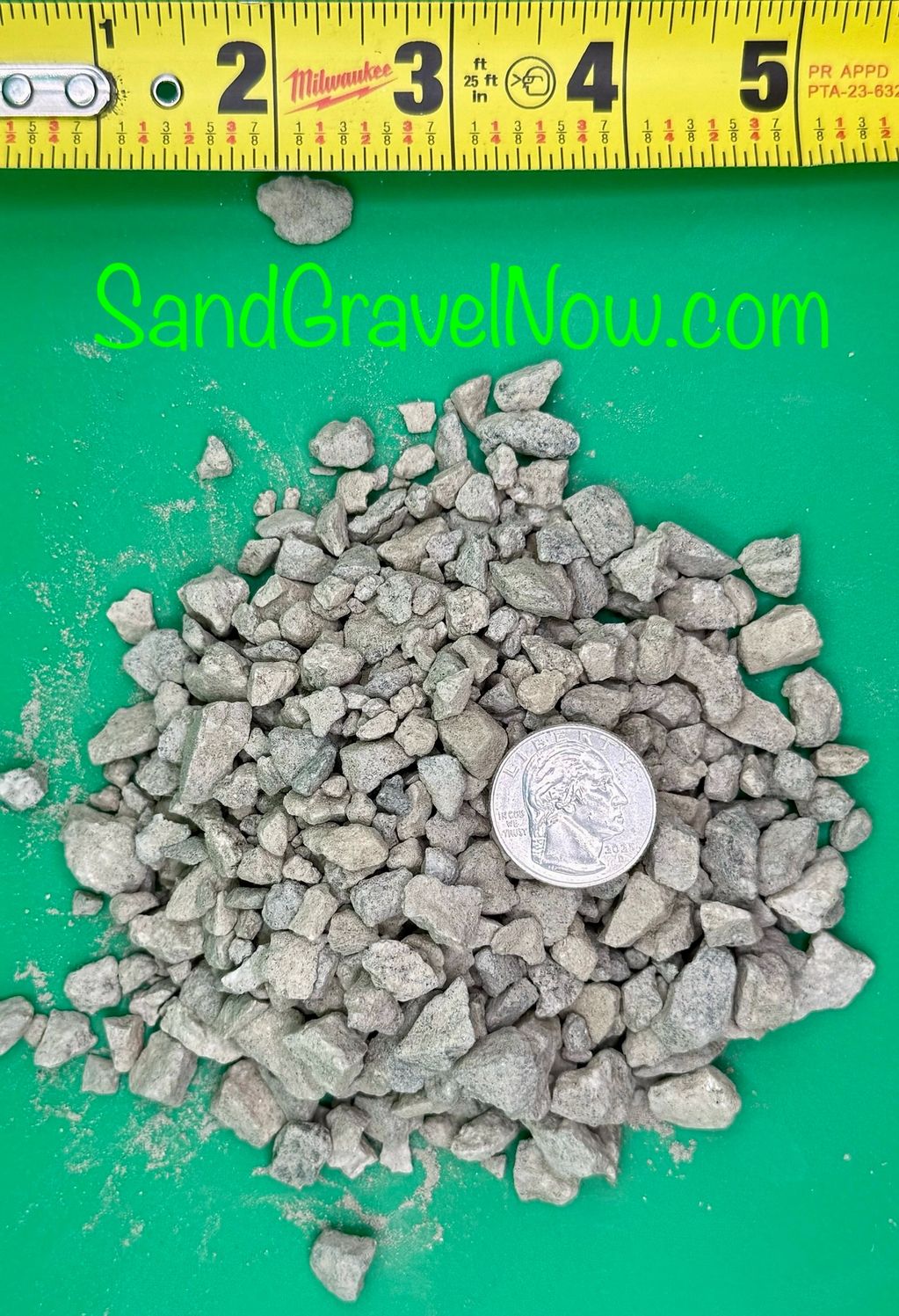 Pile of gravel with a quarter and measuring tape for size reference.