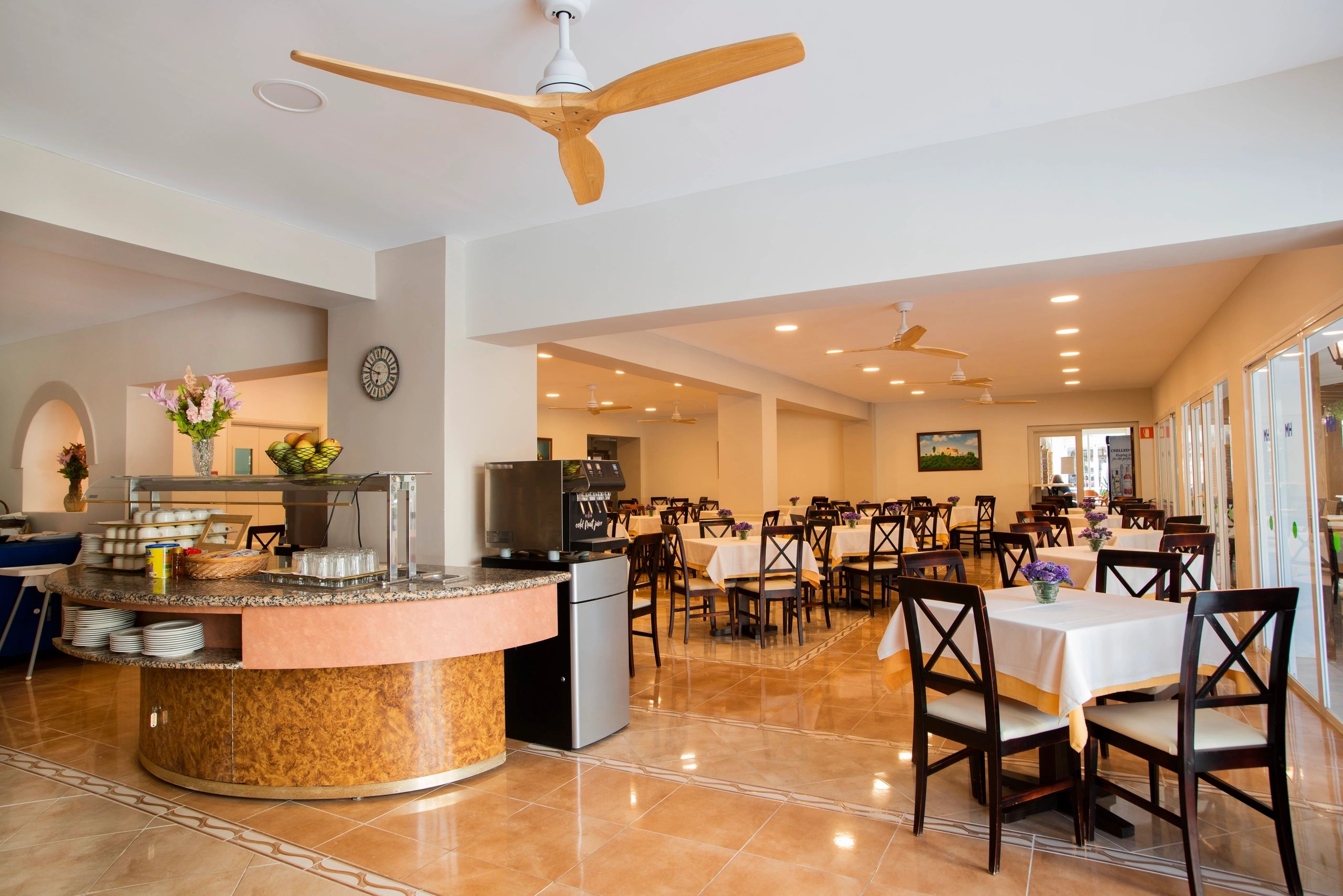 Spacious restaurant with neatly arranged tables and a serving counter.