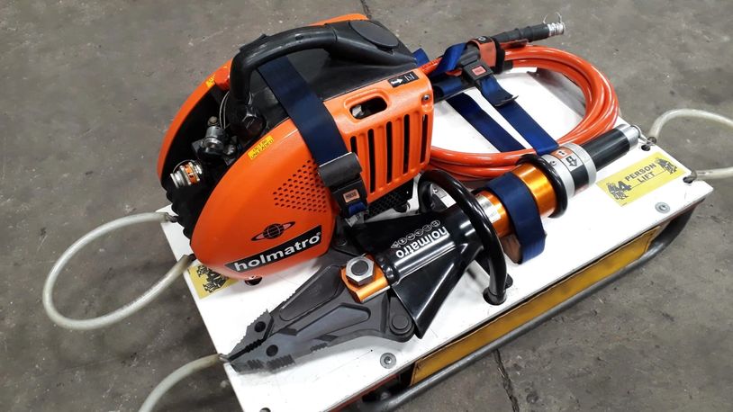 Holmatro hydraulic rescue tool on white platform.