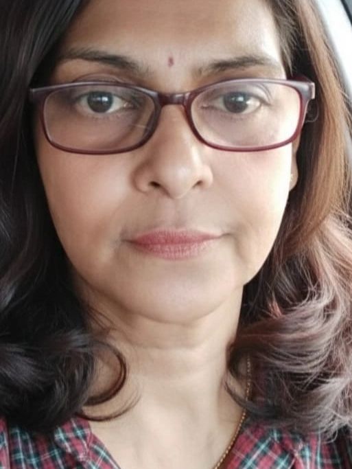 Close-up portrait of a woman wearing glasses and a checkered shirt.