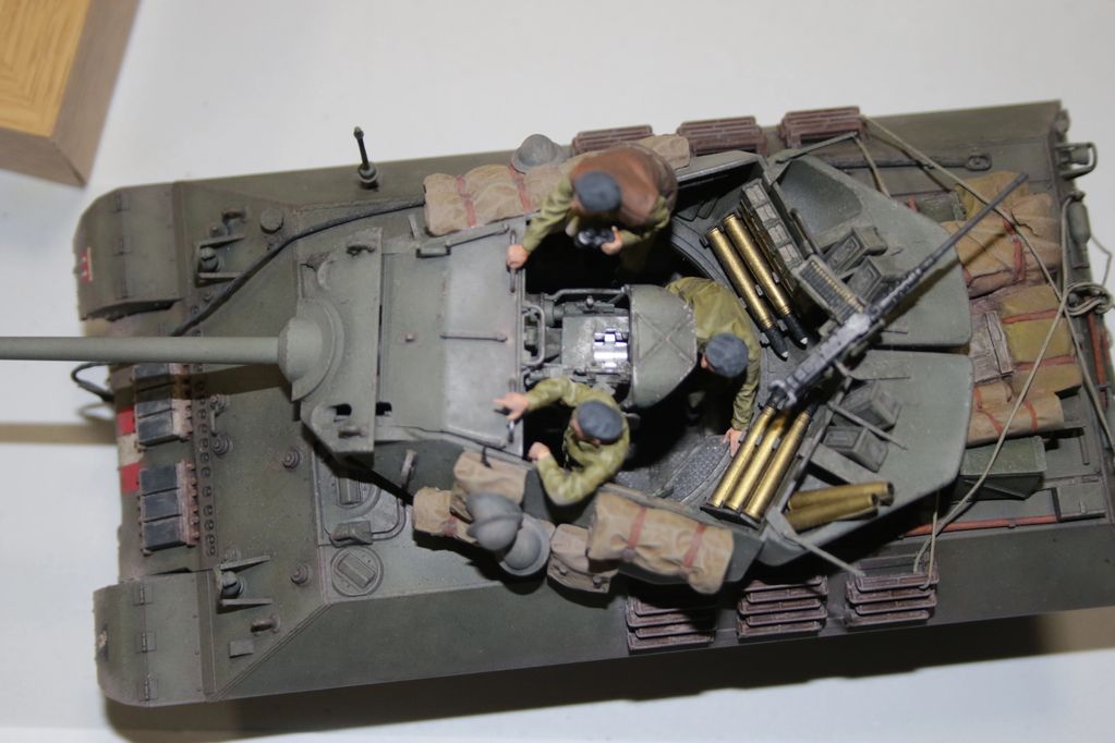 Top view of a detailed military tank model with four soldier figurines inside.