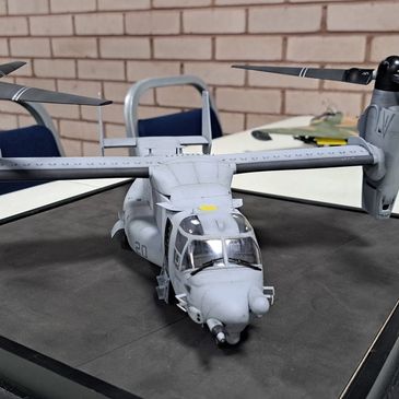 Model of a military tiltrotor aircraft displayed on a table.