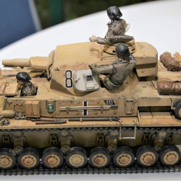 Detailed model of a German WWII tank with crew figures and weathered paint.