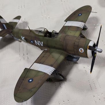 Detailed model of a WWII-era fighter plane with camouflage paint and markings.