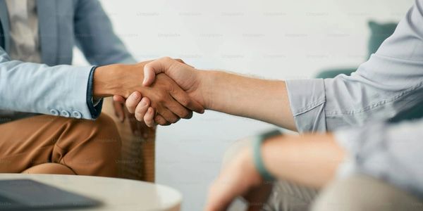 Two people shaking hands in a professional setting.