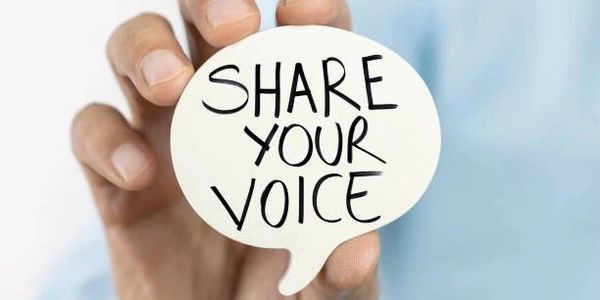 Hand holding a speech bubble with 'SHARE YOUR VOICE' text.