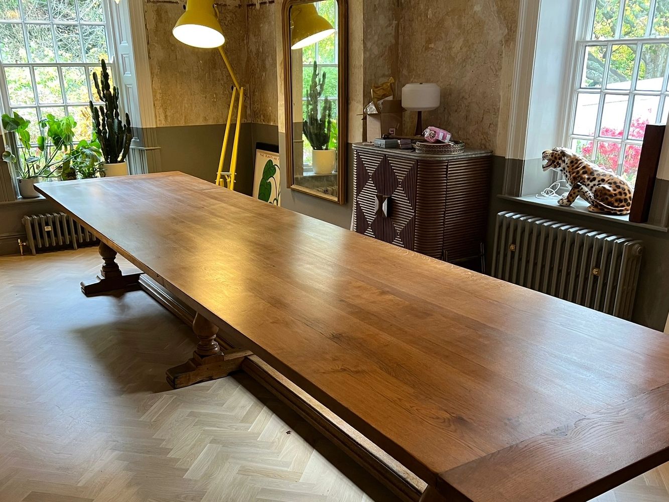 A rustic dining room with a long wooden table and eclectic decor.