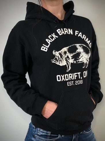 model wearing a black barn farms logo hoodie