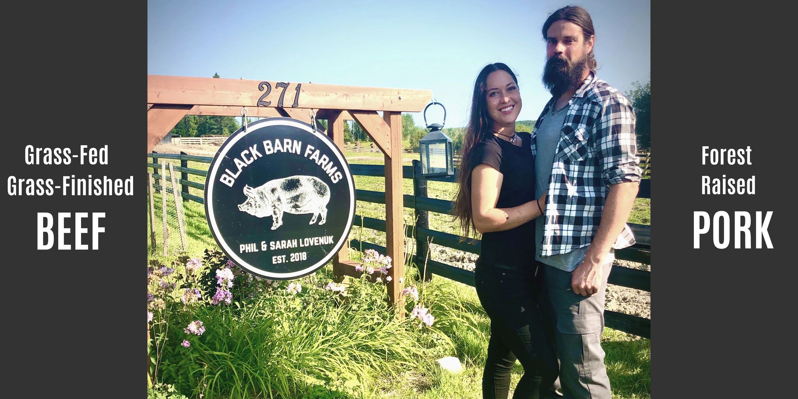 Black Barn Farm owners pose in front of the business sign and a black fence