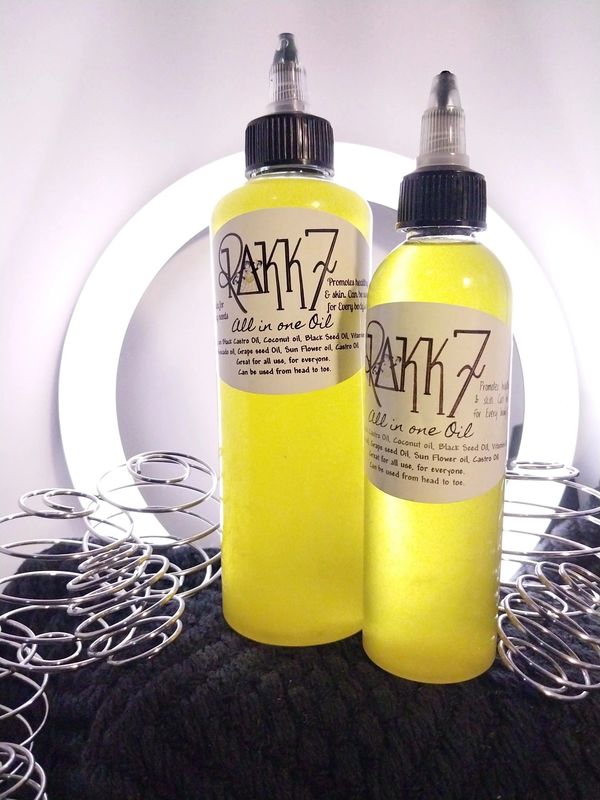 Two bottles of yellow oil labeled 'Rakkz all in one Oil' with metal rings around.