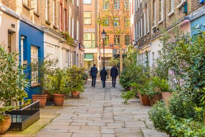 Three men walking across residential area 