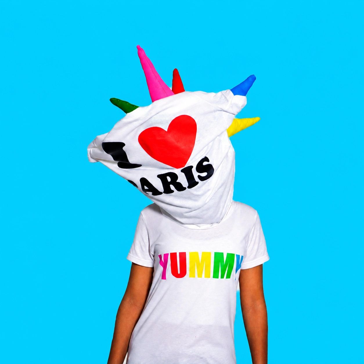 Person wearing a colorful hood with letters and spikes.