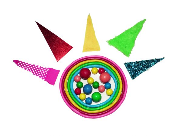 Colorful rings with various textured triangular pieces and multicolored balls arranged on a white background.