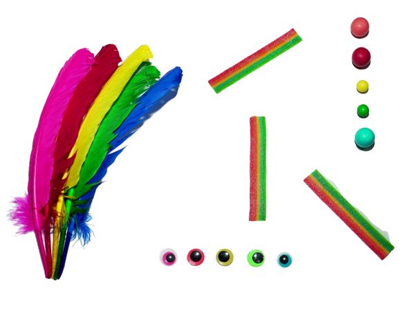 Colorful feathers, candy strips, and matching colored balls arranged on white.