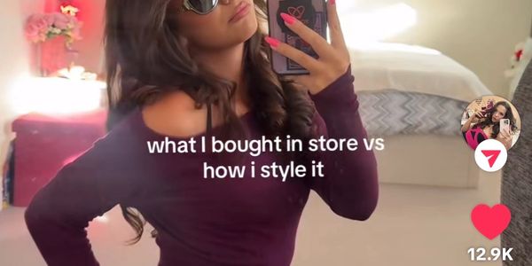 Woman taking a mirror selfie in stylish outfit with sunglasses.