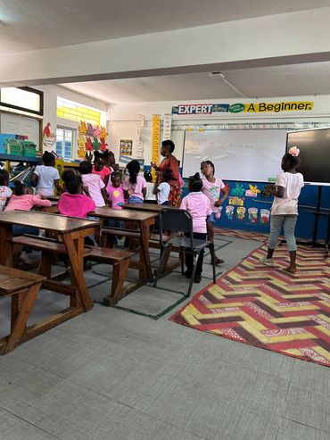 Children in a colorful classroom engaged in a lesson with their teacher.