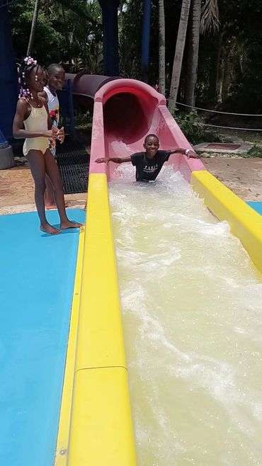 Children enjoying a water slide on a sunny day.