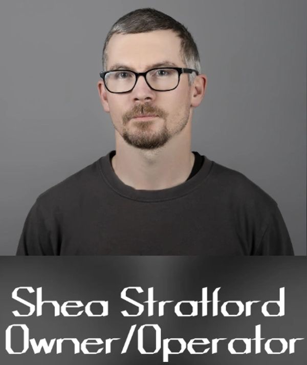 Portrait of Shea Stratford, owner and operator, wearing glasses and a dark shirt.