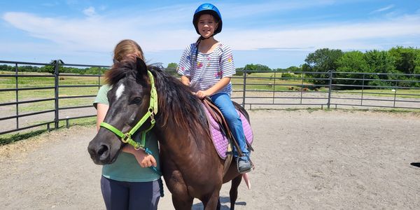 A small kid sitting on horse