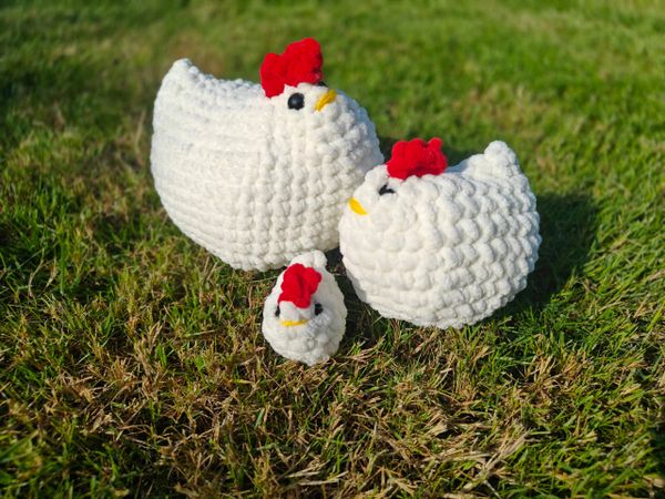 Three crochet chickens, a jumbo size, regular size, and a baby chicken.