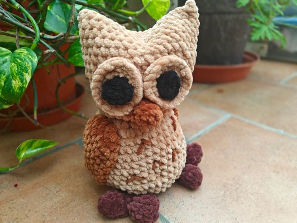 A crocheted brown owl plushie