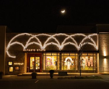 Building with decorative lights and crescent moon above at night.
