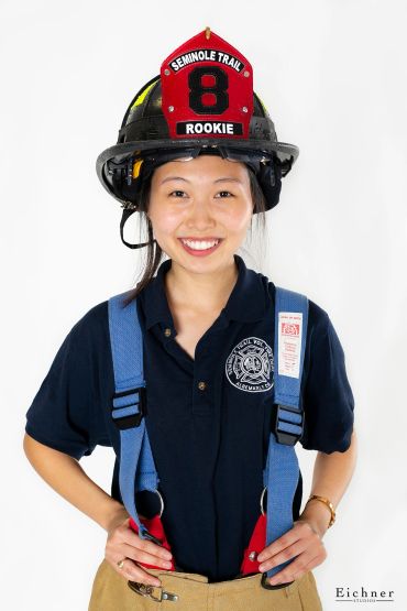 Smiling rookie firefighter wearing full gear.