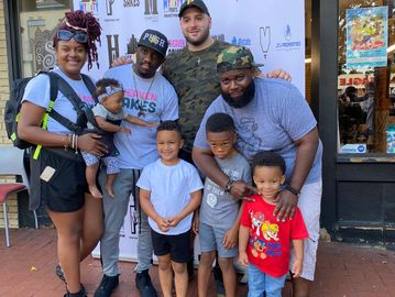 Co-founder Spencer Marnich standing with a family supported by The Dream Start Foundation