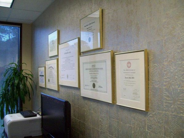 Diplomas framed and hanging on office wall