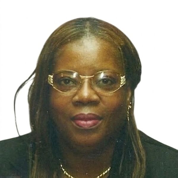 Portrait of a woman wearing glasses and a necklace.