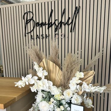 Elegant floral arrangement at Bombshell Lash Co. reception area.