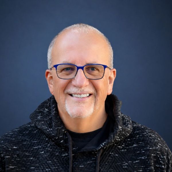 Smiling man with glasses and a gray beard.