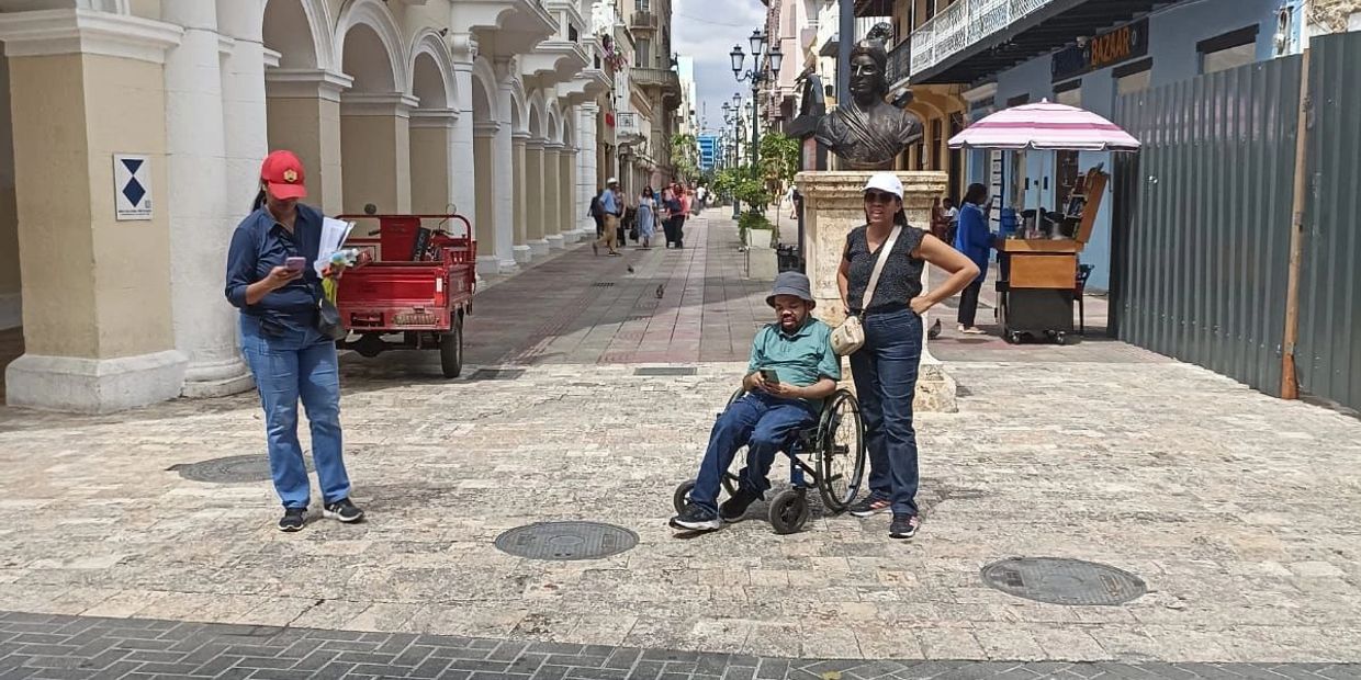 Persona usuaria de silla de ruedas recorre una calle de la Ciudad Colonial.