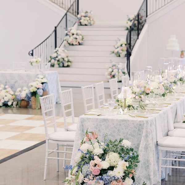 Elegant wedding reception setup with floral arrangements and white decor.