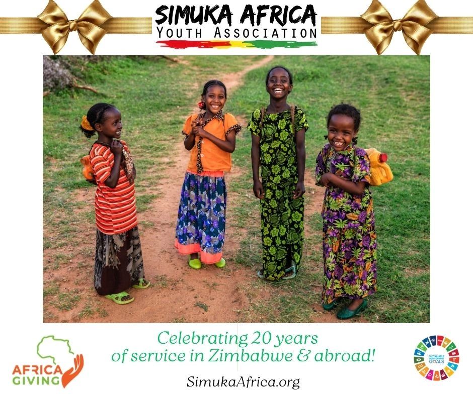 Four joyful African children in colorful traditional attire standing outdoors.