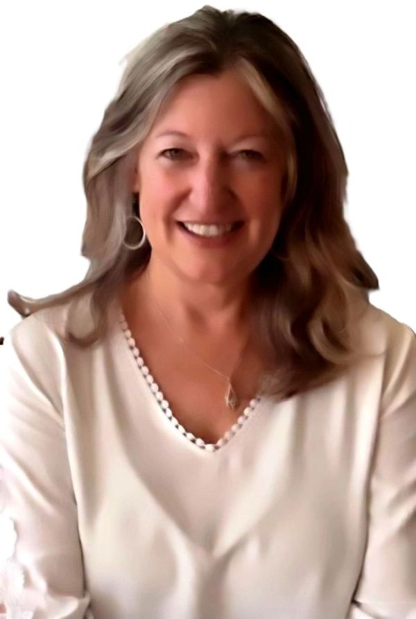 Smiling woman with shoulder-length hair wearing a white top.