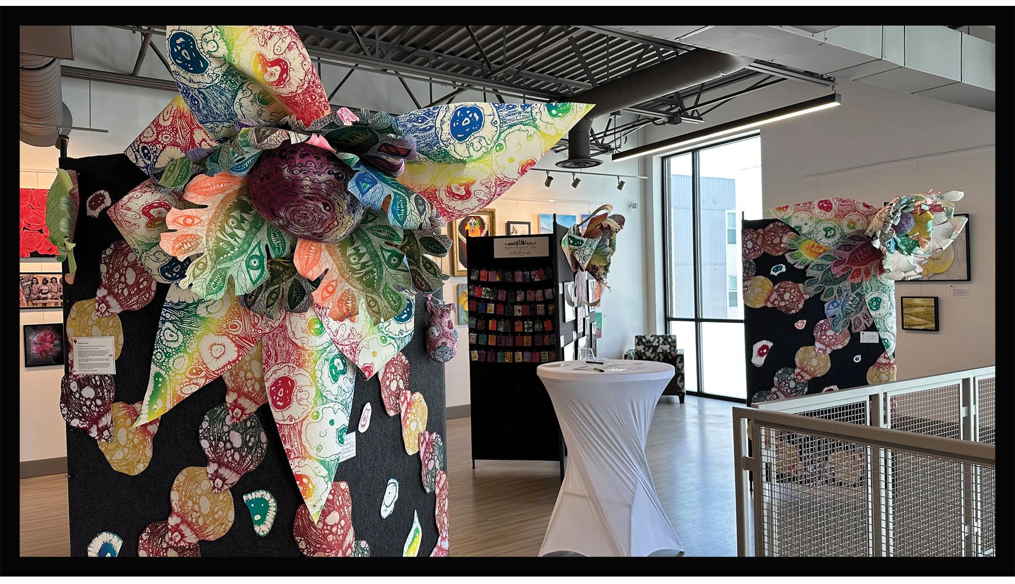 Colorful abstract floral art installations displayed in a modern gallery space.