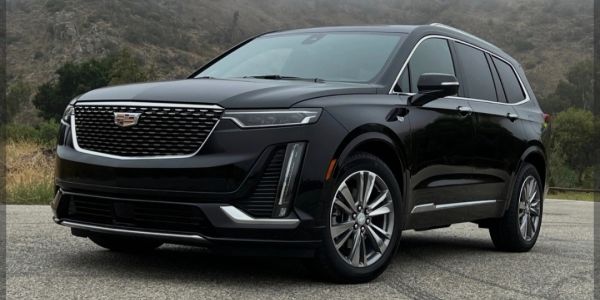 Black Cadillac SUV parked outdoors on pavement.