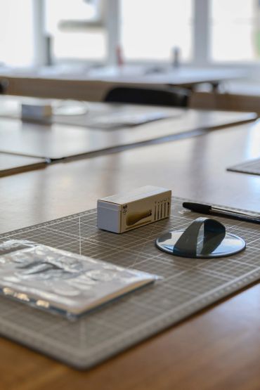 Art supplies arranged neatly on a cutting mat in a bright workspace.