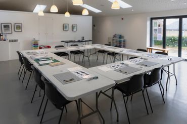 Modern meeting room with U-shaped table setup and materials.