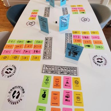 A tabel set up with cards from the game Conflicting Interests