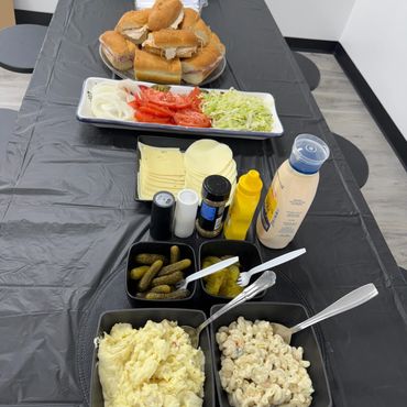 A table with sandwich ingredients and sides.