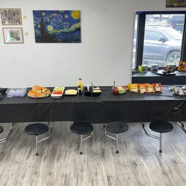 Buffet setup with bread, condiments, and snacks.