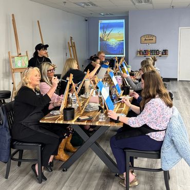 Group painting class with easels and drinks.