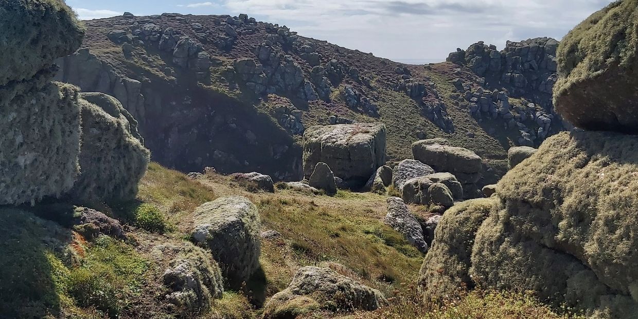 a photo taken on the South West coast path near Nanjizal Cove. The natural rock forms an entranceway