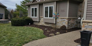 House with manicured landscaped bed and fresh mulch.