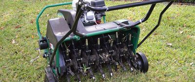 A plug aerator machine that is plugging the lawn.