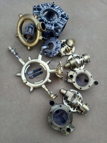 Various brass and metal mechanical parts arranged on the floor.
