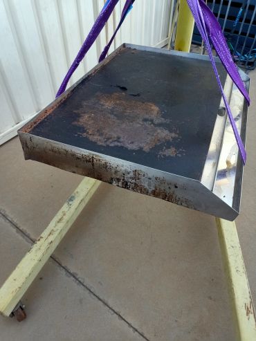 A rusty metal platform suspended by purple straps.