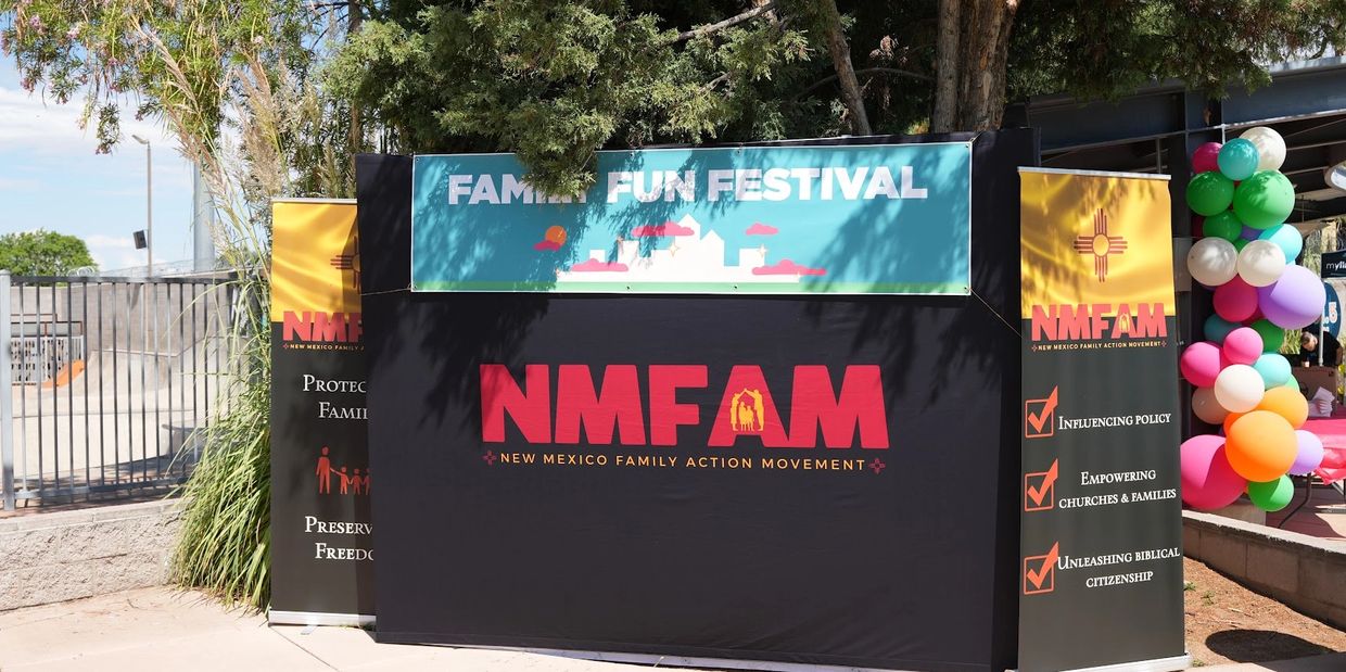 NMFAM booth at a family fun festival with colorful balloons.